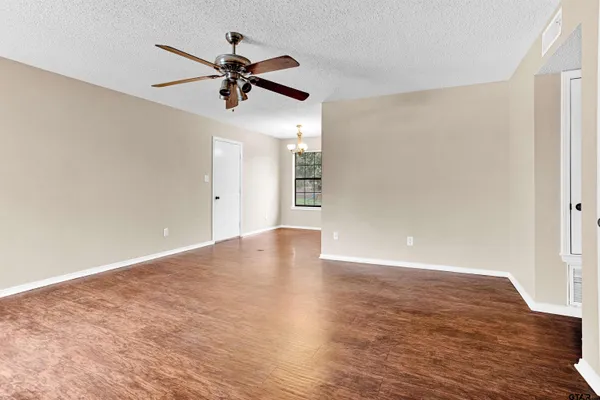 a view of a livingroom with a ceiling fan and wooden floor