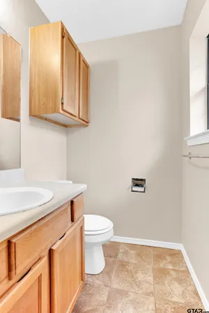 a bathroom with a granite countertop sink and a toilet