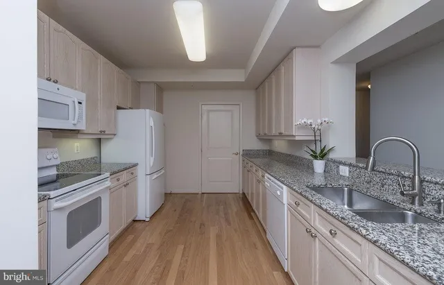 a kitchen with granite countertop a sink stove and refrigerator