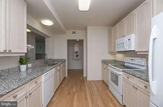 a kitchen with a sink stove top oven and refrigerator