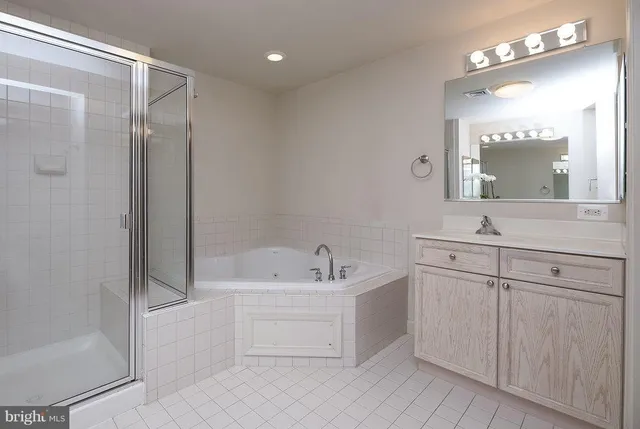 a bathroom with a bathtub shower sink and mirror