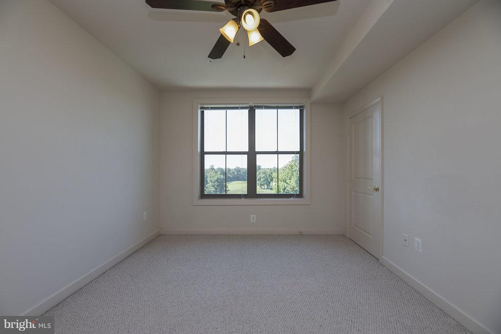 485 Harbor Side Street, Unit 710 Woodbridge, VA 22191 - Photo 10 of 26 an empty room with a chandelier fan and windows