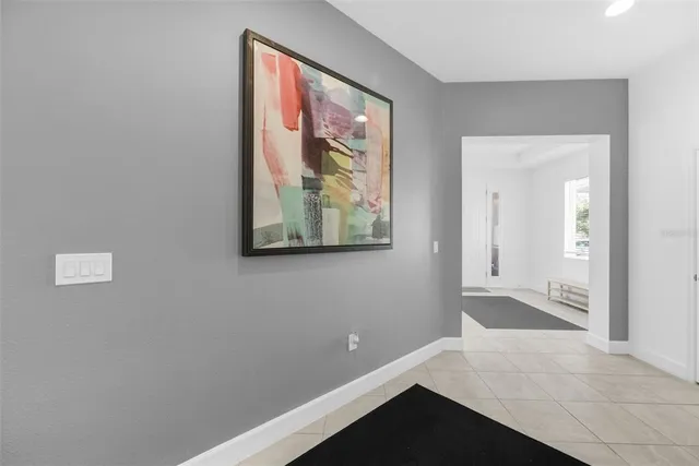 a room with painting on the wall and a potted plant