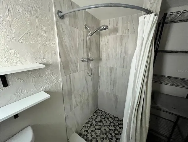 a bathroom with a shower and a sink