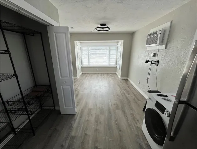 a view of a hallway with wooden floor and a sink
