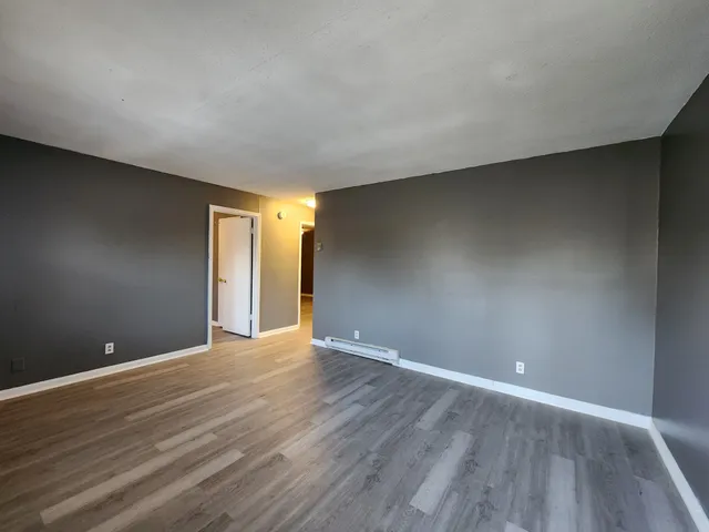 a view of an empty room with wooden floor