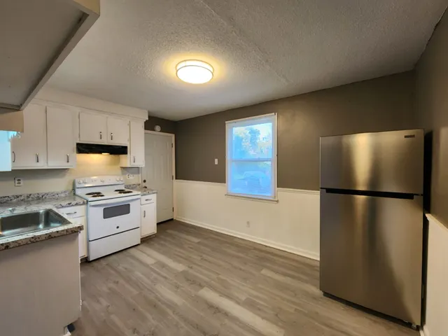 a kitchen with stainless steel appliances a refrigerator a stove a sink and a microwave