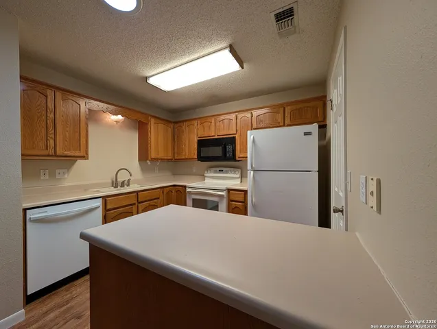 a kitchen with stainless steel appliances a refrigerator sink stove microwave and cabinets