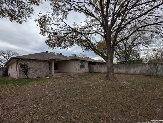 a tree in front of a white house