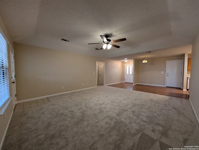 a view of an empty room with a ceiling fan