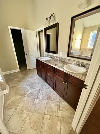 a bathroom with a double vanity sink and mirror