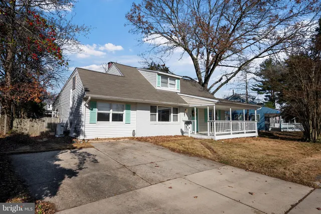 a kitchen with a sink dishwasher a stove and white cabinets with wooden floor