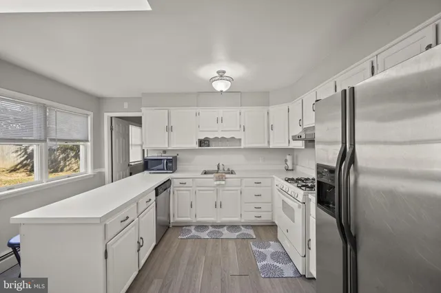 a kitchen with a table chairs cabinets and wooden floor