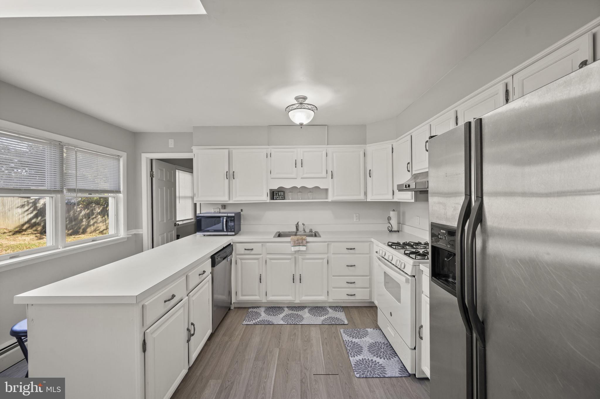 3 Leymar Road Glen Burnie, MD 21060 - Photo 17 of 60 a kitchen with white cabinets and stainless steel appliances
