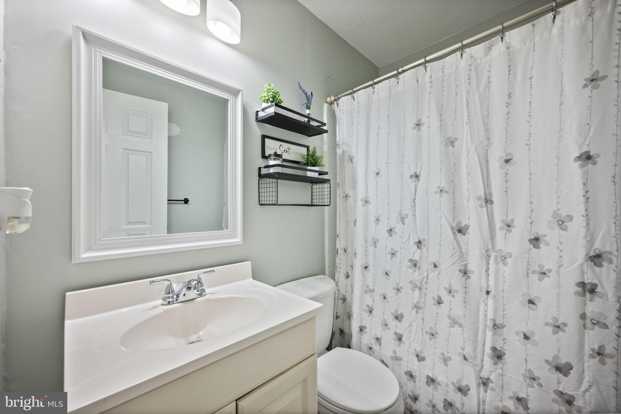 3 Leymar Road Glen Burnie, MD 21060 - Photo 39 of 60 a bathroom with a sink a toilet and shower curtain