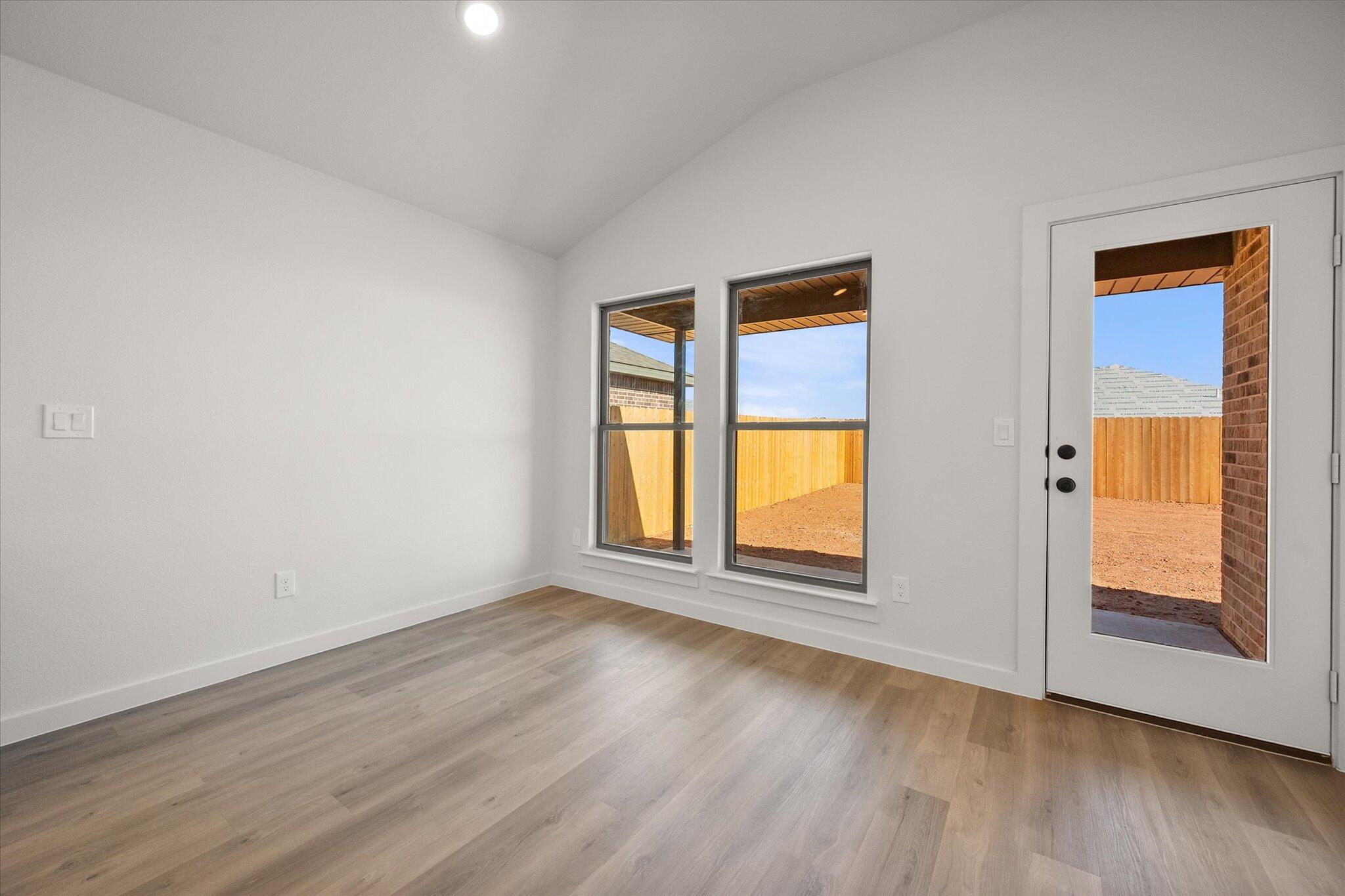 2422 Aberdeen Avenue Wolfforth, TX 79382 - Photo 13 of 23 an empty room with wooden floor and windows