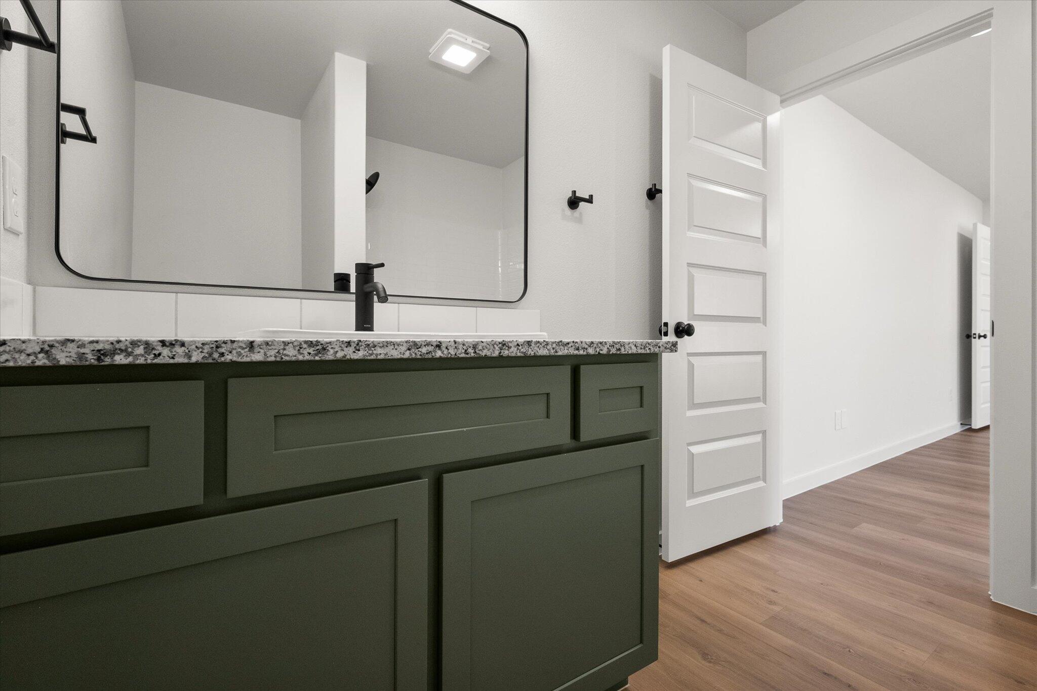 2422 Aberdeen Avenue Wolfforth, TX 79382 - Photo 16 of 23 a bathroom with a granite countertop sink and a mirror
