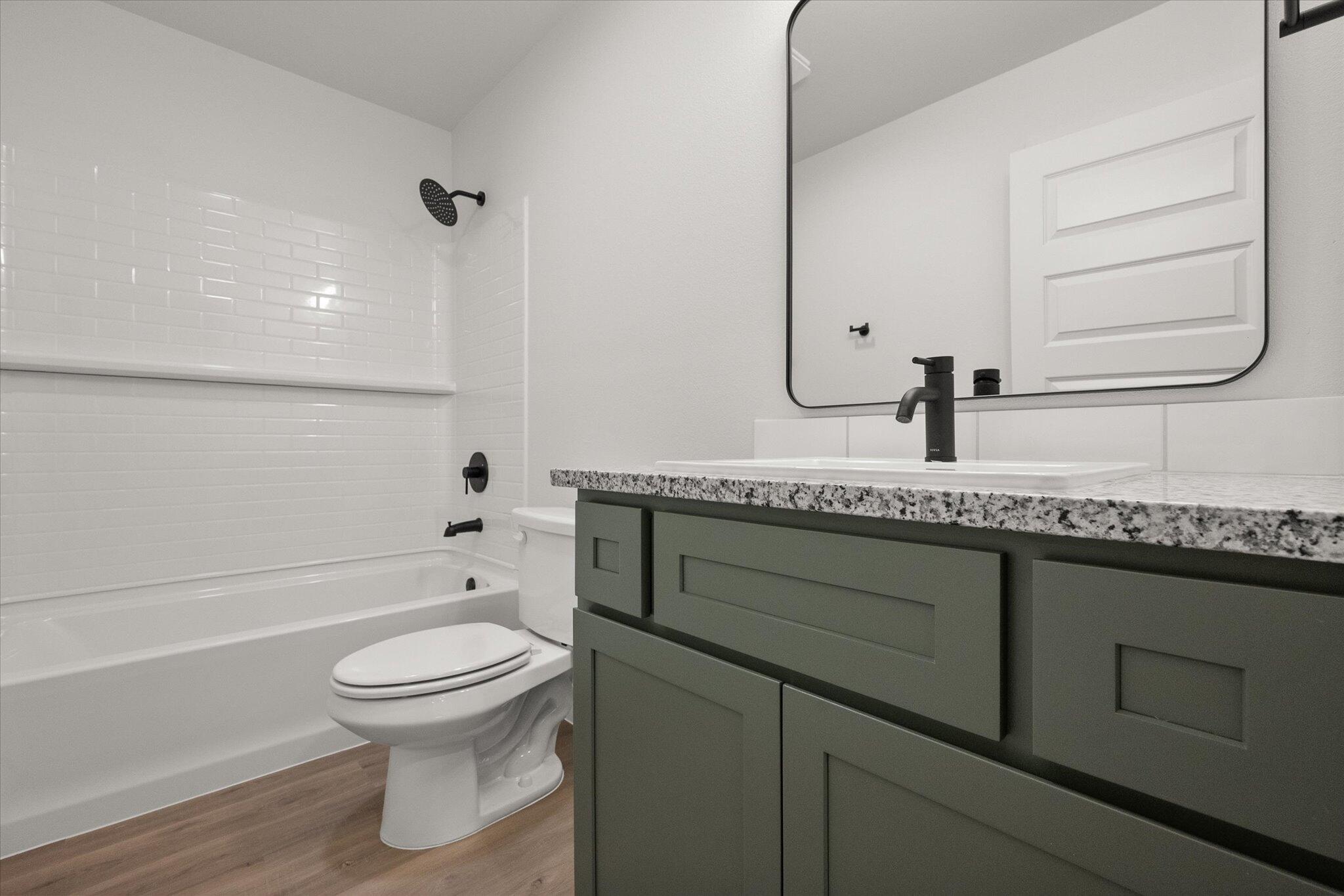 2422 Aberdeen Avenue Wolfforth, TX 79382 - Photo 20 of 23 a bathroom with a granite countertop sink toilet and mirror