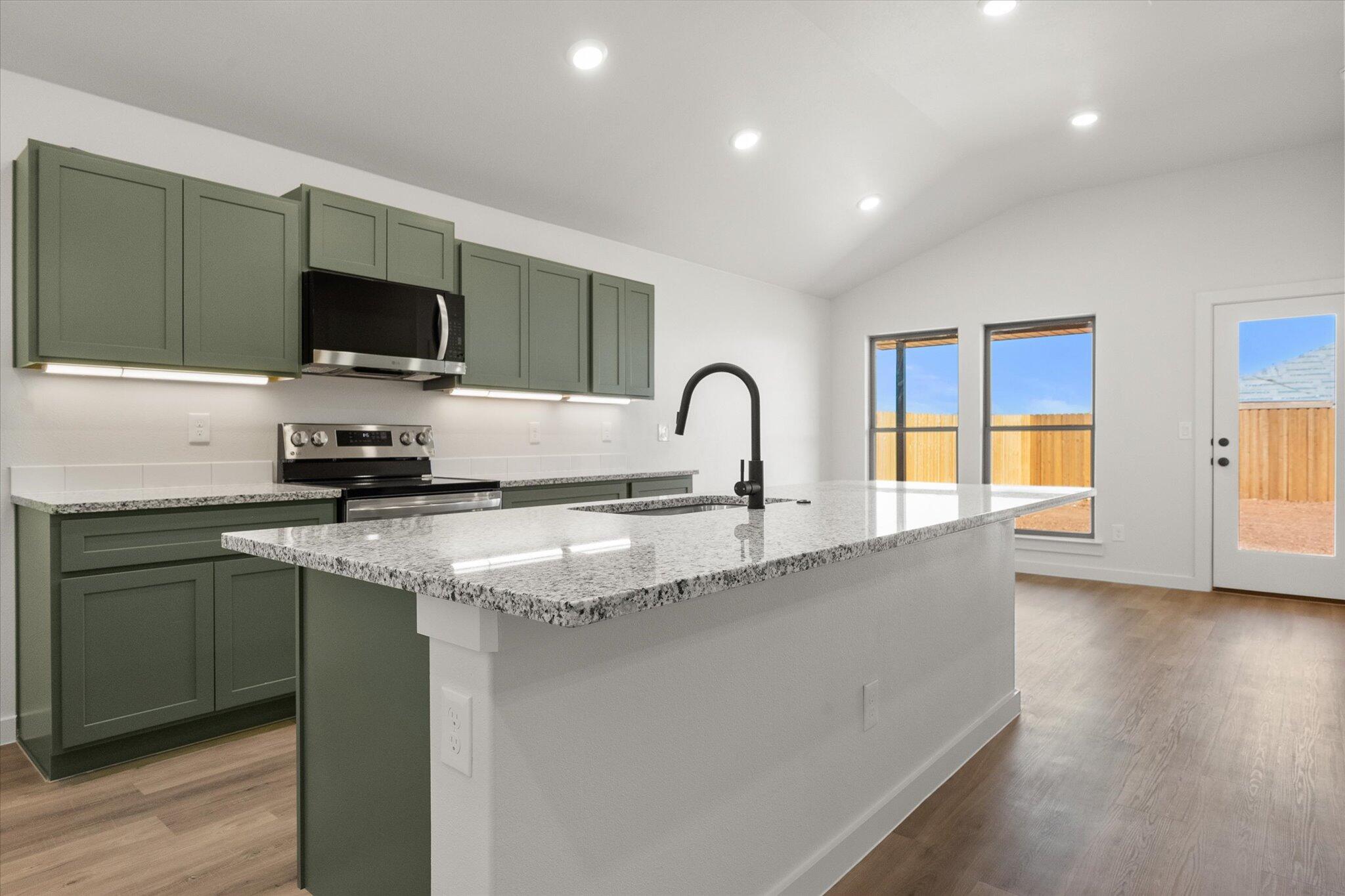 2422 Aberdeen Avenue Wolfforth, TX 79382 - Photo 7 of 23 a kitchen with granite countertop a sink and a stove top oven