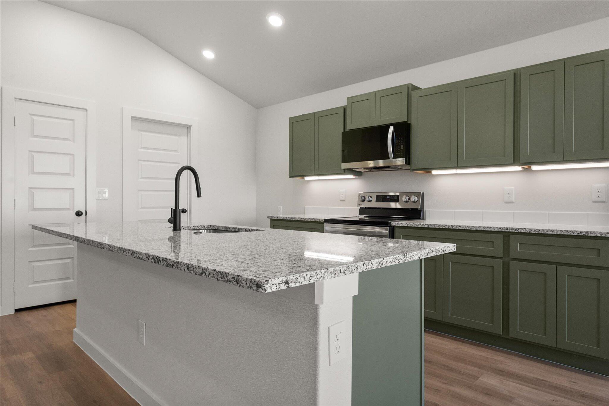 2422 Aberdeen Avenue Wolfforth, TX 79382 - Photo 9 of 23 a kitchen with a sink and a stove top oven with wooden floor