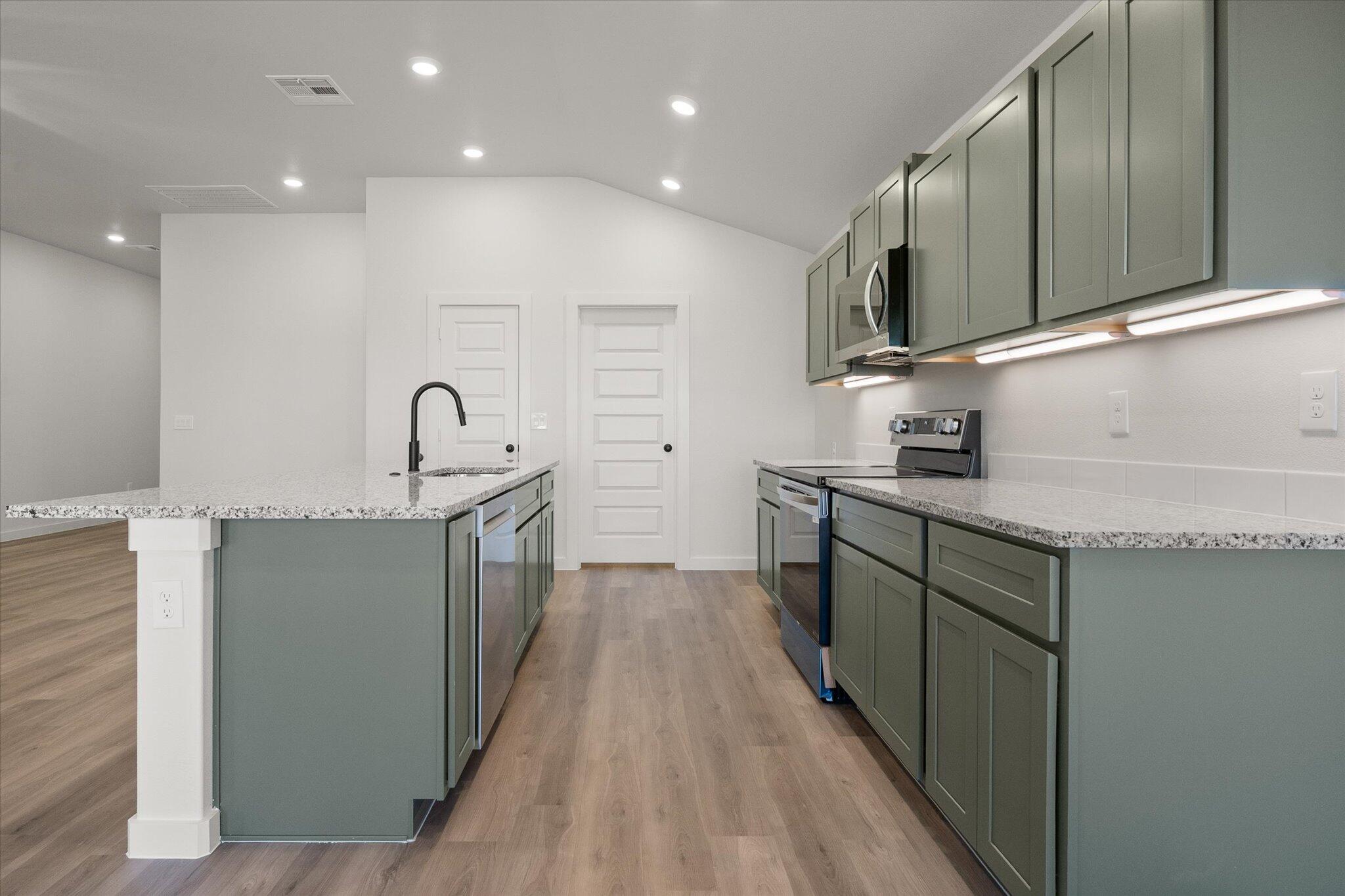 2422 Aberdeen Avenue Wolfforth, TX 79382 - Photo 10 of 23 a kitchen with stainless steel appliances a sink stove and cabinets
