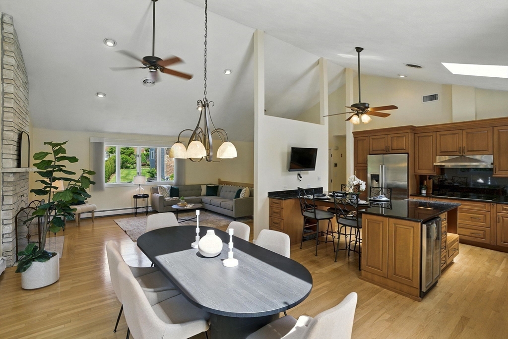 a view of a dining room and a livingroom with furniture wooden floor a chandelier