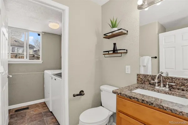 a bathroom with a granite countertop sink a toilet and a mirror