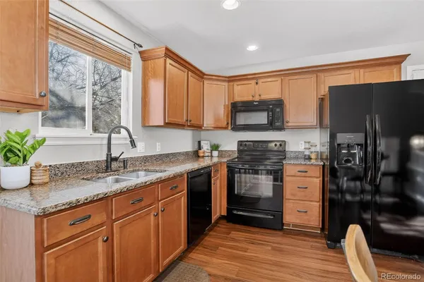 a kitchen with stainless steel appliances granite countertop a stove a sink and a refrigerator