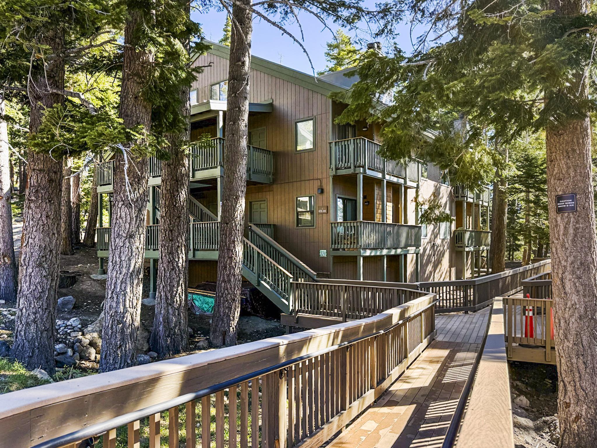 153 Lake Mary Road, Unit 114 Mammoth Lakes, CA 93546 - Photo 16 of 22 Multi-level residential building featuring wood siding and multiple balconies with dark green railings