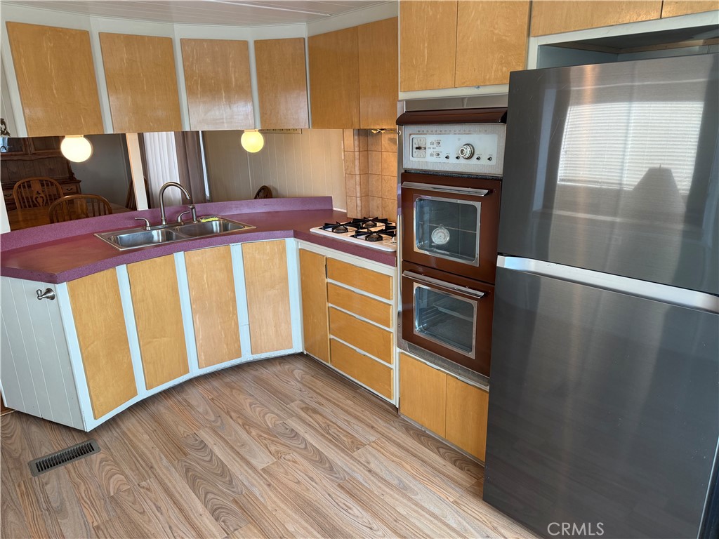 1701 Los Osos Valley Road, Unit 39 Los Osos, CA 93402 - Photo 13 of 18 a kitchen with stainless steel appliances granite countertop a refrigerator a stove and a wooden floor