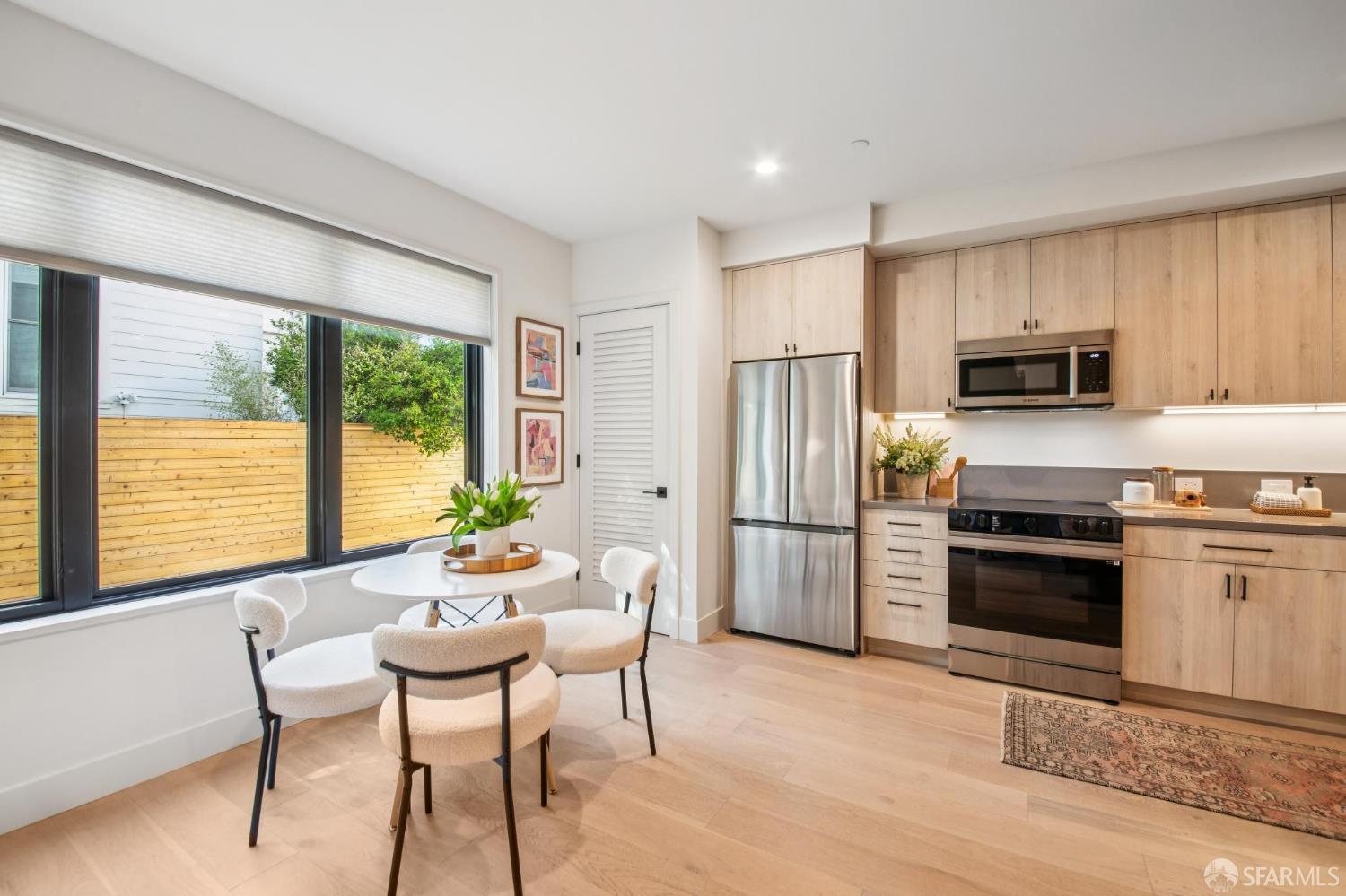 986 South Van Ness Avenue, Unit 203 San Francisco, CA 94110 - Photo 12 of 34 a kitchen with stainless steel appliances wooden floor and a refrigerator