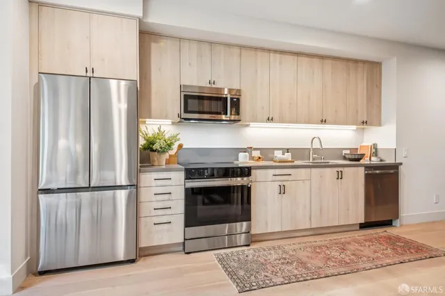 a kitchen with granite countertop a refrigerator stove and microwave