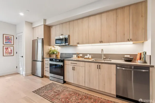 a kitchen with stainless steel appliances granite countertop a refrigerator sink and stove