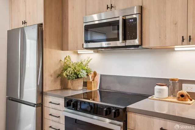 a kitchen with stainless steel appliances a microwave and cabinets