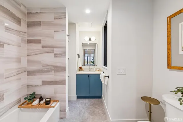 a bathroom with a tub sink and mirror