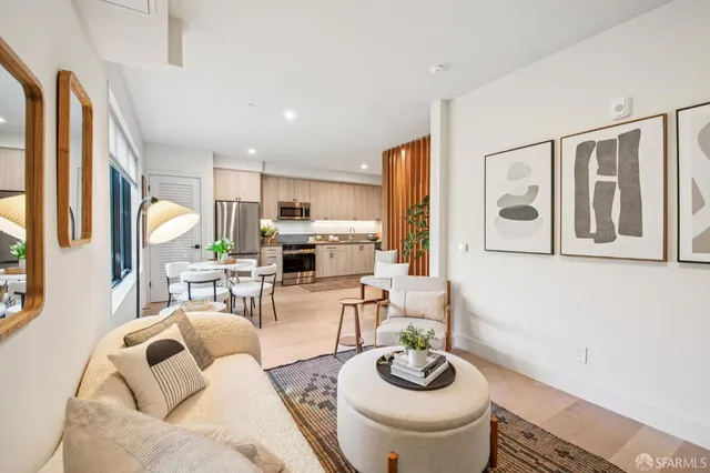 a living room with furniture kitchen view and a window