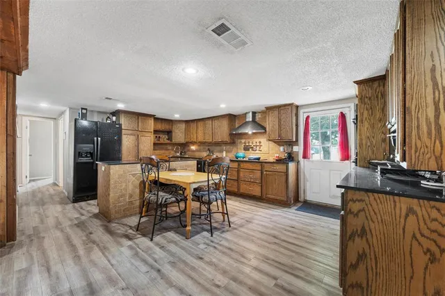 a kitchen with stainless steel appliances kitchen island granite countertop a sink cabinets and wooden floor