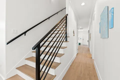 a view of a hallway with wooden floor and staircase