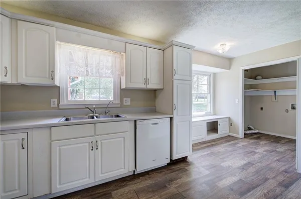 a kitchen with cabinets appliances a sink and a window