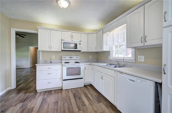 a kitchen with white cabinets and a window