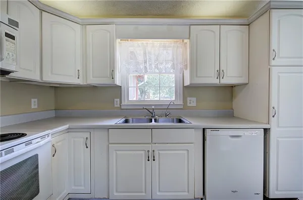 a kitchen with cabinets stainless steel appliances and a sink