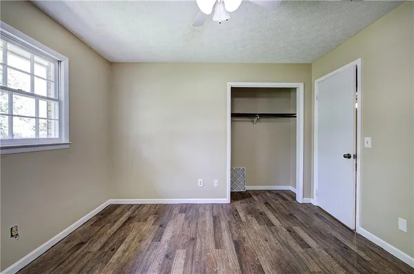 a spacious bathroom with a double vanity sink a toilet and a mirror