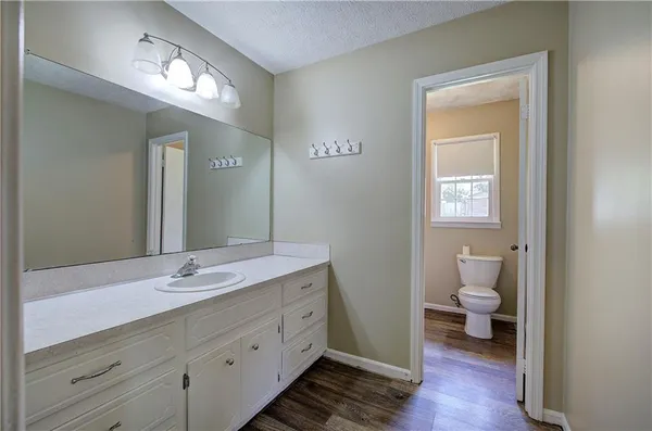a bathroom with a toilet sink and mirror