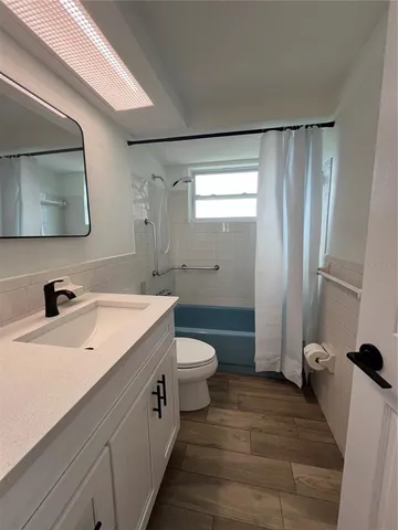 a spacious bathroom with a double vanity sink toilet and mirror