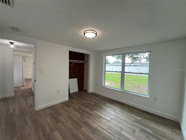 an empty room with wooden floor and a window
