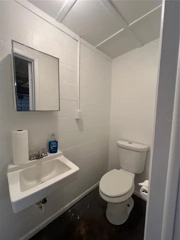 a bathroom with a sink a toilet and mirror