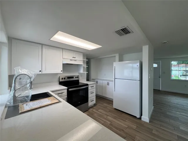 a kitchen with stainless steel appliances granite countertop a refrigerator stove and sink