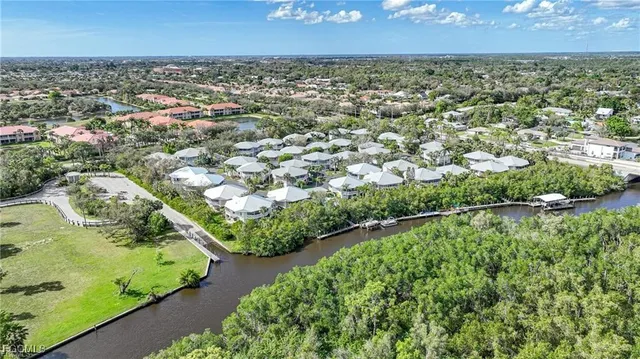 an aerial view of residential houses with outdoor space and trees