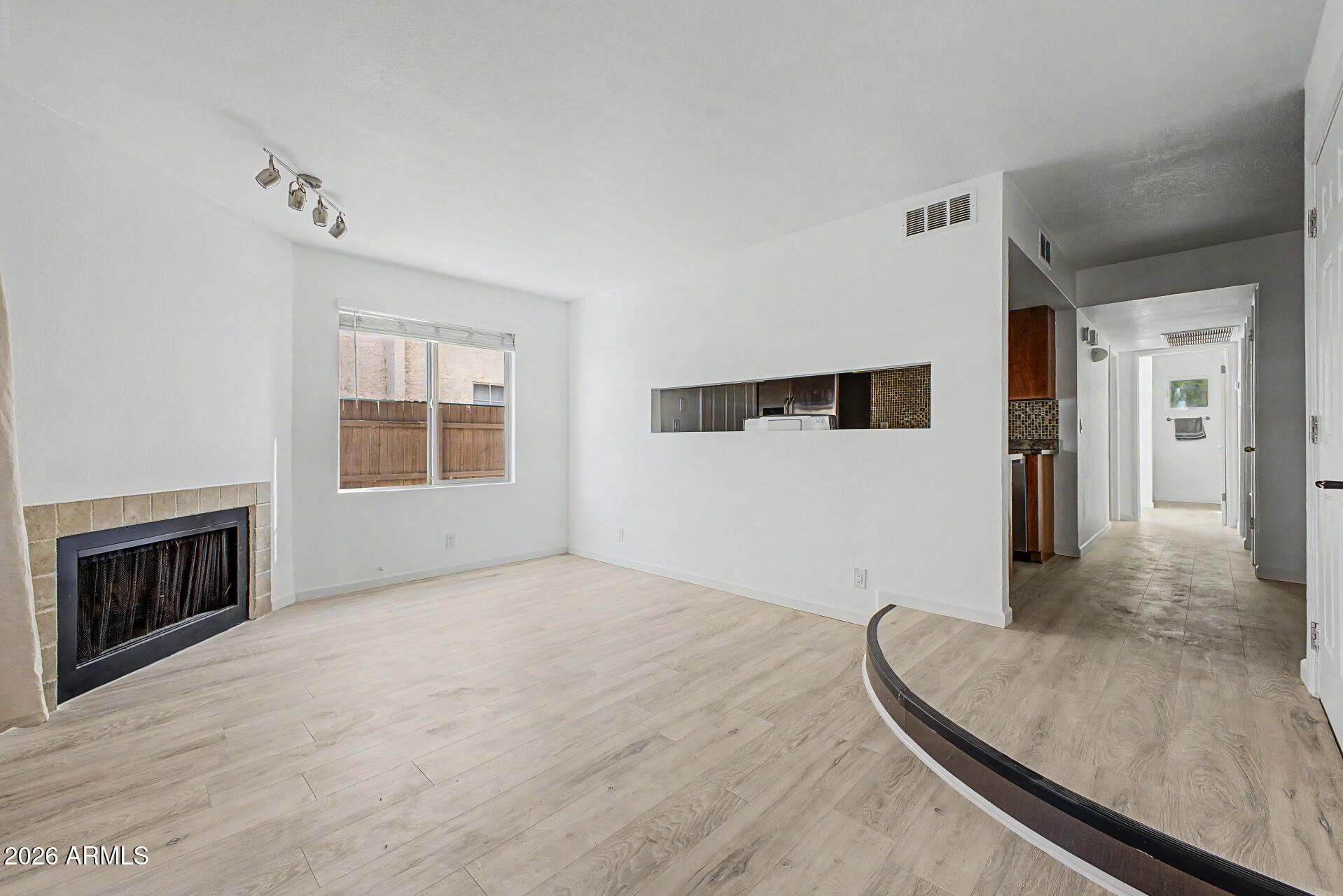 a view of an empty room with a fireplace and a window