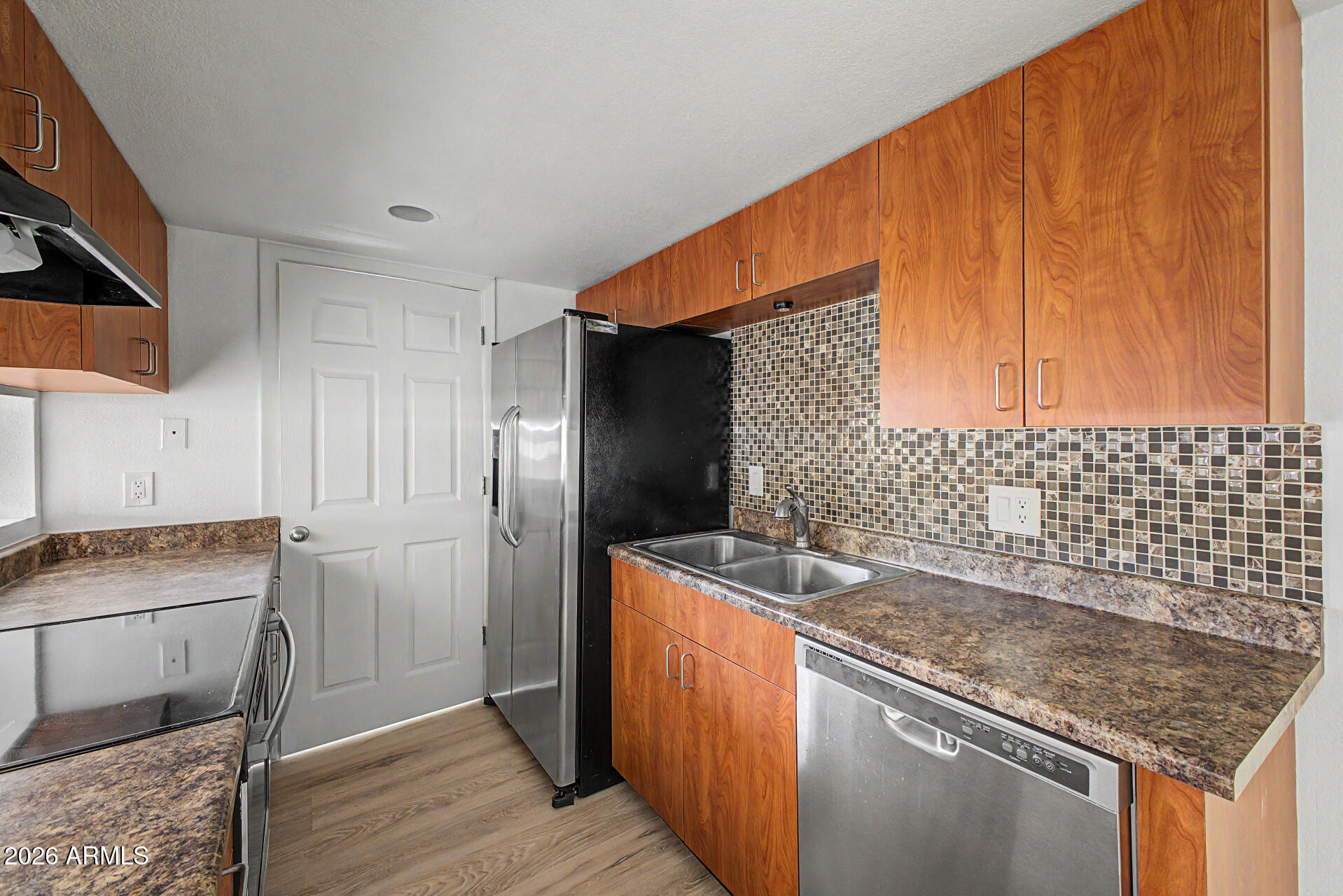 3422 North 12th Place Phoenix, AZ 85014 - Photo 11 of 49 a kitchen with stainless steel appliances granite countertop a sink stove and refrigerator